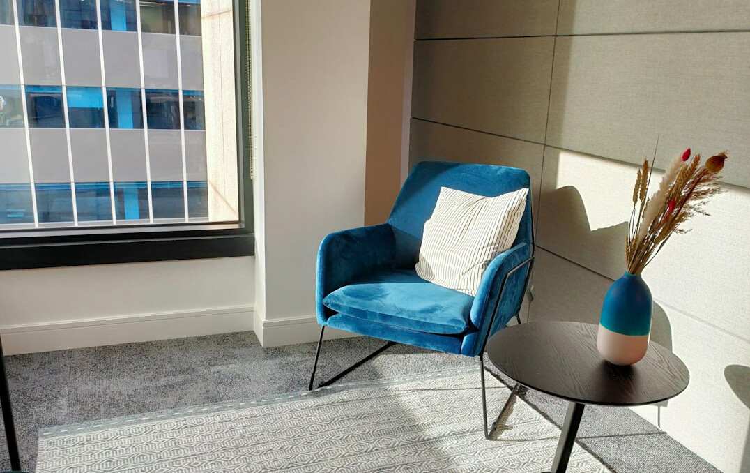 Calm office relaxation corner with plants and soft seating for mental wellbeing